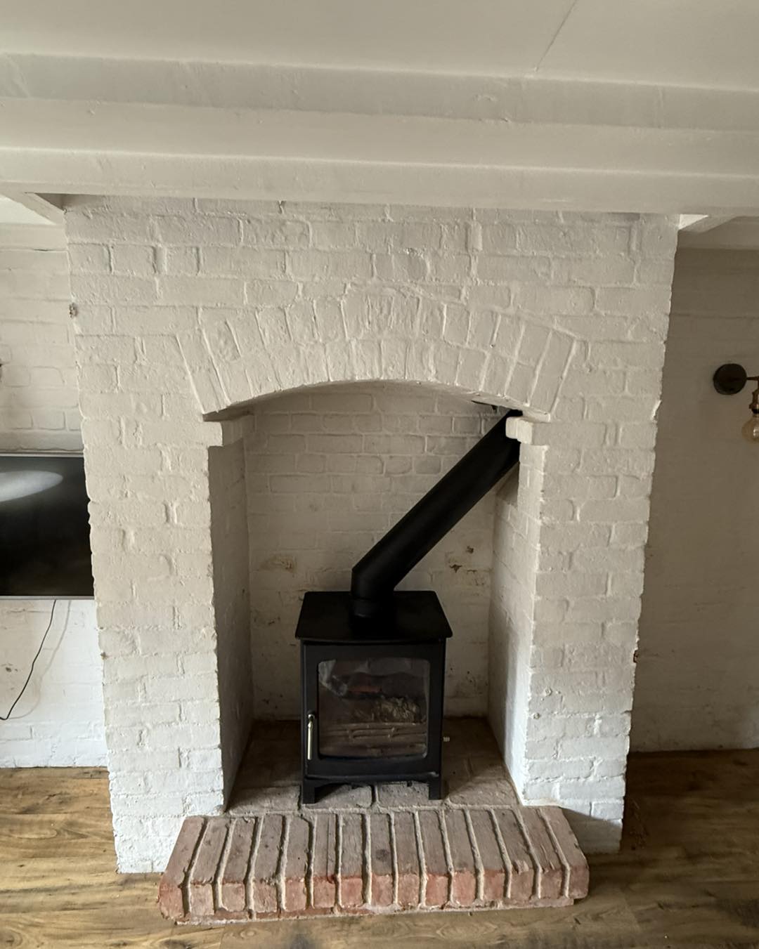 Whitewashed brick chimney breast with stove, Bishop's Stortford
